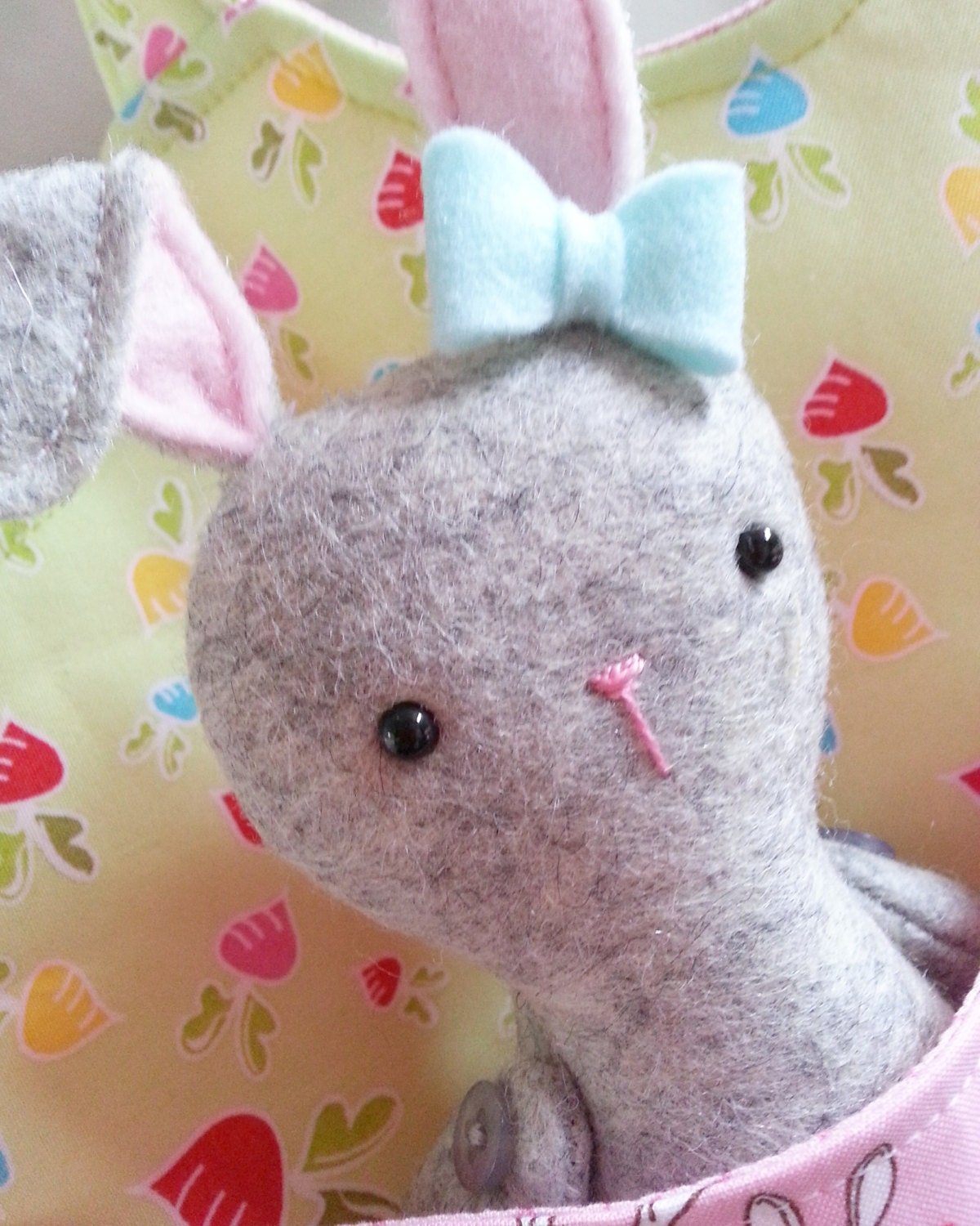 close up of grey felt rabbit with blue bow on its ear