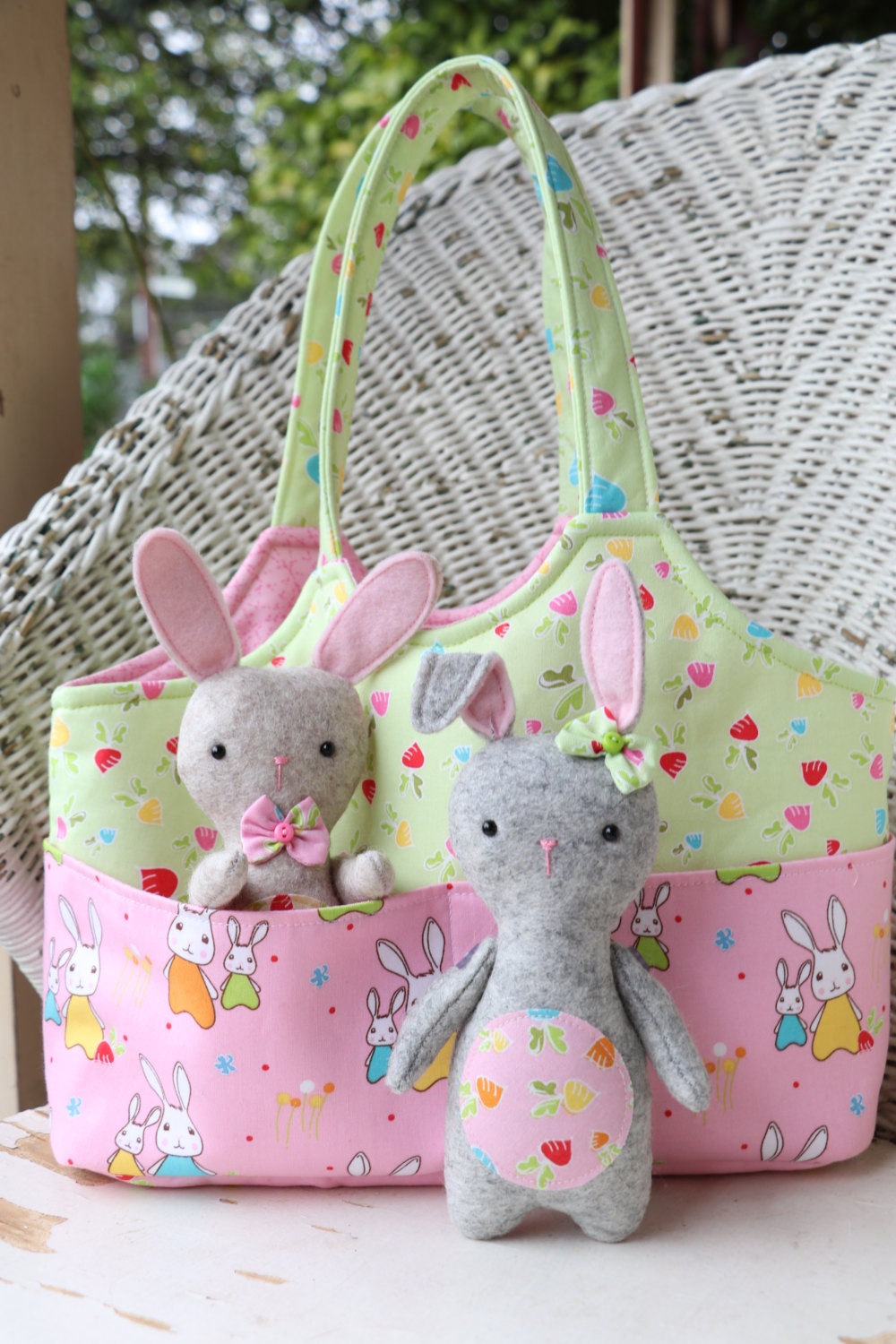 A small easter bag with front pockets holding two felt bunny toys