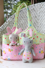 Load image into Gallery viewer, A small easter bag with front pockets holding two felt bunny toys
