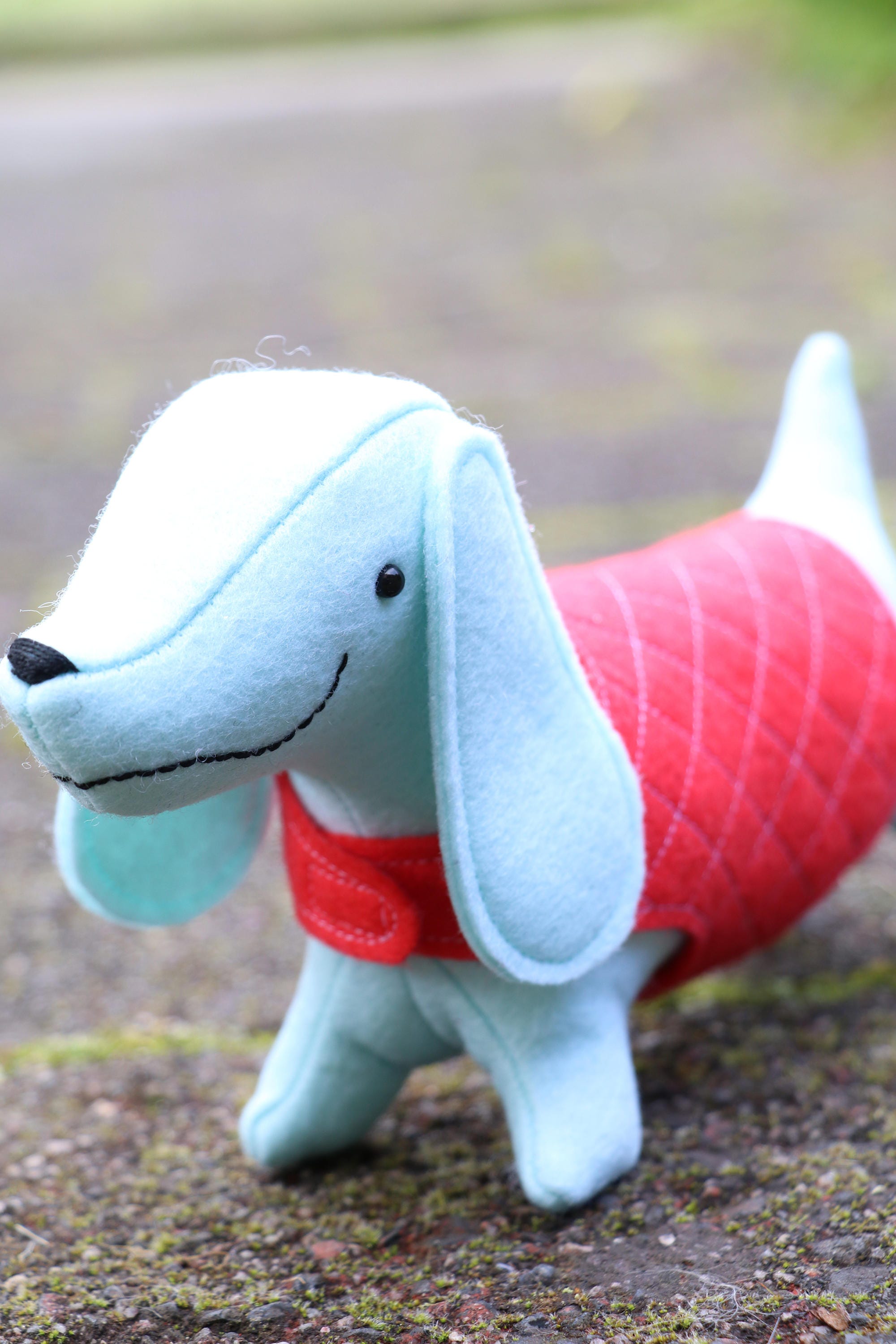 blue felt sausage dog toy in pink coat