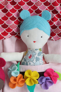 close up of small doll with blue hair