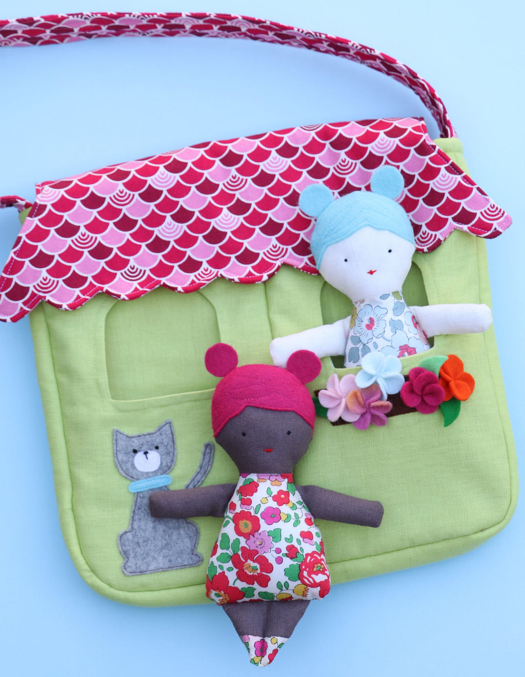 two dolls in a bag that looks like a house