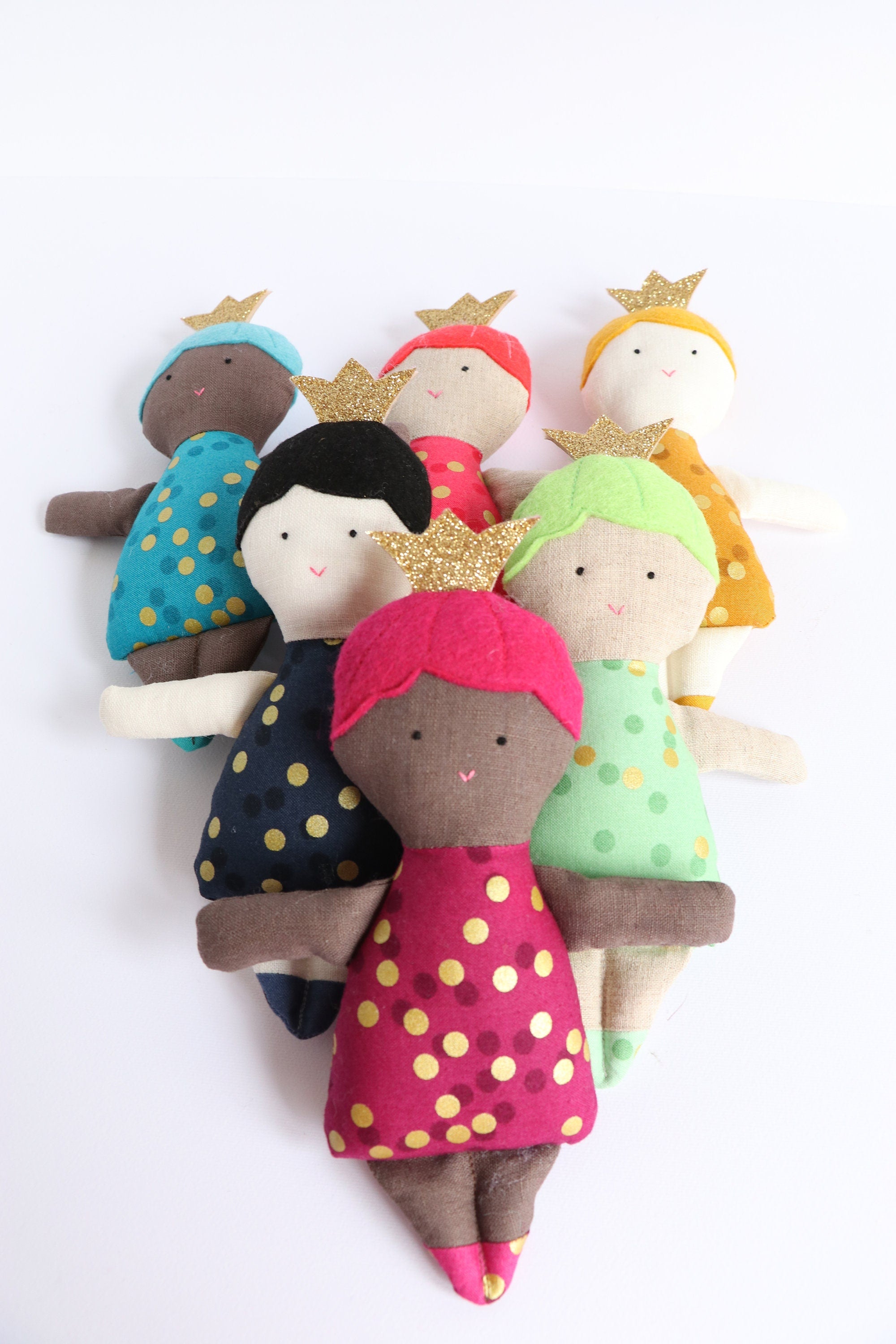 six dolls wearing crowns