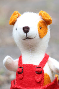 white felt dog wearing red overalls