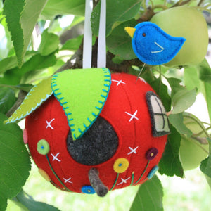 red felt apple hanging in a tree